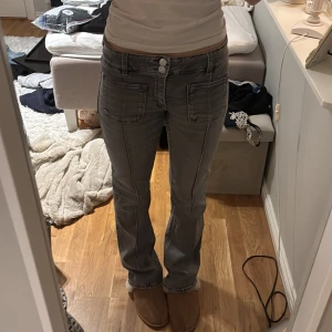 Grå low waist bootcut jeans med fickor - Grå jeans från Gina 