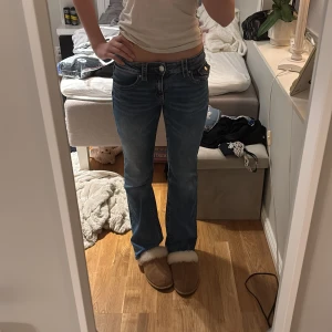 Blå bootcut jeans - Snygga blå bootcut jeans med låg midja och klassisk femficksdesign. 