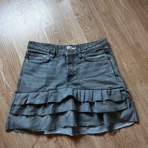 Grå jeanskjol! - Snygg grå jeanskjol från 157 med volangdetaljer. Kjolen är omsydd från byxor av förra ägaren och var tyvärr för stor för mig!
