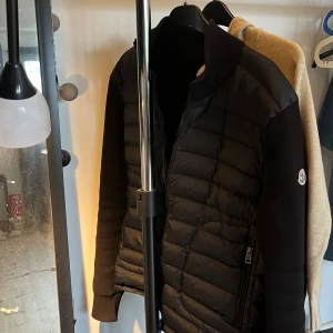 Svart cardigan jacka från Moncler - Snygg svart cardigan jacka från Moncler som är perfekt för vår, sommar och höst. Kan bevisa att den är äkta förutom att jag inte har fysiskt kvitto men jag har digitalt kvitto🙌 skicket är strålande och håller en bra bit framåt👊 hör av dig vid funderingar. ❗️Pris ej hugget i sten❗️