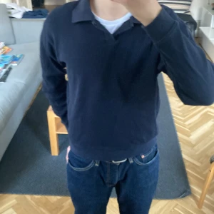 Mörkblå pikétröja från Zara - Säljer en stilren svart  pikétröja från Zara. Tröjan har långa ärmar och en klassisk krage. Perfekt för en avslappnad men ändå snygg look.