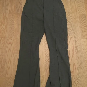 Grå kostymbyxor - Snygga grå kostymbyxor med mid waist och vida ben. Använd nån enstaka gång. Normal i storleken 