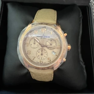 Klocka från Bernhard H. Mayer - Säljer en elegant klocka från Bernhard H. Mayer med ett stilrent beige armband och en urtavla i guldton. Klockan har flera små urtavlor och kommer i en snygg presentförpackning. Perfekt för den som vill ha en tidlös accessoar. Målat i äkta rosa guld, aldrig använt, pris går att diskutera