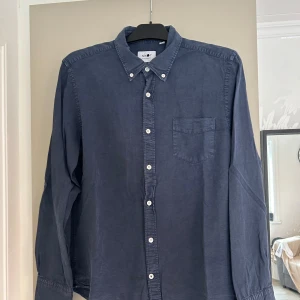 Mörkblå skjorta från NN07 - Snygg mörkblå skjorta i gött material från NN07 med klassisk krage och knappar framtill. Passar som M