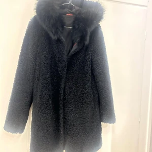 Svart Joplin teddyjacka med pälskrage från Rock & Blue - Säljer en snygg svart teddyjacka med en fluffig pälskrage. Jackan har långa ärmar och är perfekt för kyliga dagar. Den är både stilren och mysig, vilket gör den till ett måste i garderoben året runt! Populär modell från rock & blue som heter Joplin. Nypris 2500. Sparsamt använd så i jätte fint skick!