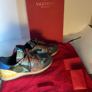 Valentino Rockrunner sneakers i camouflage - Snygga Valentino Rockrunner sneakers med ett coolt camouflage-mönster i grönt, blått och brunt. Skorna har bruna snören och en robust sula med bra grepp. Perfekta för en trendig look.pris kan diskuteras vid snabb affär 