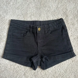Lågmidjade svarta jeansshorts - Säljer dessa så snygga shorts i mycket bra skick. Midjemåttet mätt rakt över är 33 cm och innebensmåttet är cirka 3,5 cm. Uppskattad storlek xxs-xs, men ursprungligen barnstorlek. Så fina verkligen! Finns resår att justera storleken.