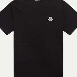 Svart t-shirt från Moncler - Snygg svart t-shirt från Moncler. Skicka ett meddelande för fler bilder så löser vi det direkt🫡. Nypris ca 2500, Får med kvitto. Går även att skanna logon! NYSKICK!?! Säljs billigt pågrund av utrensning