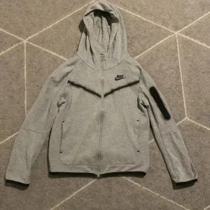 Nike tech/ Grå - Nike tack i grå är i bra form och är ej sönder elr sliten. Storlek 137-147 den är en 8/10, jag köpte den för 1000 från Nike… men säljer den för 400kr, om du har tåget eller ett annat pris?? Skriv till mig…..😃😄