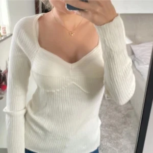 Vit ribbad tröja från Zara - Säljer en stilren vit ribbad tröja från Zara. Tröjan har en v-ringad design och långa ärmar, perfekt för en chic och bekväm look. Passar bra till både jeans och kjol. Perfekt för höst och vår! Storlek 40 men passar även S som jag har!