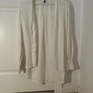 Vit silkes skjorta från Amisu - Elegant vit silkes skjorta från Amisu med långa ärmar och en stilren design. Perfekt för en chic och minimalistisk look. Tillverkad i ett mjukt och bekvämt material.