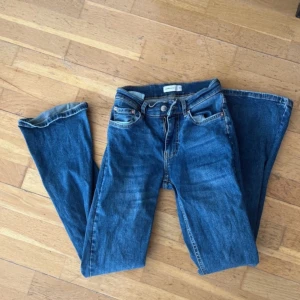 Blå jeansbyxor - Säljer ett par klassiska blå jeansbyxor med normal passform. De har en dragkedja och knappar framtill. Perfekta för en avslappnad stil.