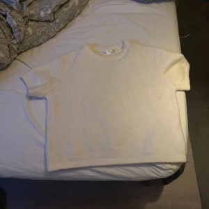 Beige kortärmad tröja - Säljer en stickad beige tröja med korta ärmar. Perfekt för en avslappnad look. Tröjan har en enkel design och är gjord i ett mjukt material. köpt på gina young i storlek 146/152 med passar mig som brukar ha xs/s