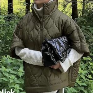 Olivgrön quiltad jacka - Säljer en olivgrön quiltad jacka med hög krage och korta ärmar. Jackan har en oversized passform och är perfekt för lager-på-lager-stil. Den har en dragkedja framtill och är gjord i ett syntetmaterial som ger en cool look.