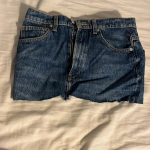 Blå jeans kjol från mango - Snygga blå jeans kjol från MNG med rå kant och klassisk femficksdesign. Perfekta för en avslappnad stil. De har en dragkedja och knapp framtill för enkel stängning. säljer på grund av att den är för liten tyvärr❣️