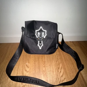Svart axelväska från Trapstar - Snygg svart axelväska från Trapstar med justerbar axelrem. Väskan är i nyskick och har använts inte mer än en gång sedan jag fick den för ett år sen. PRISET GÅR ATT FÖRHANDLA 