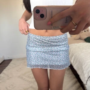 Blå mini kjol - Mini kjol blå o blommig