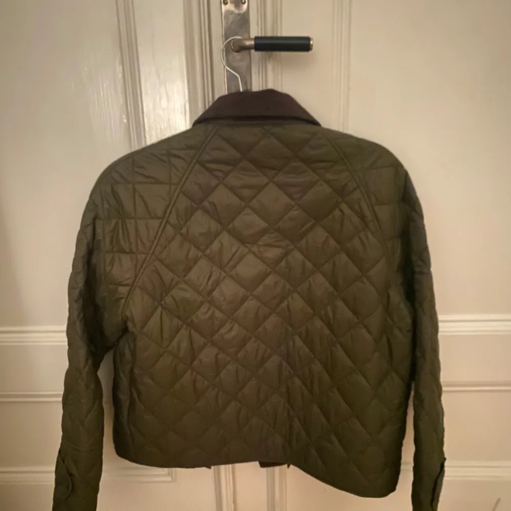 Säljer en snygg olivgrön jacka från Massimo Dutti. Jackan har en klassisk krage och stängs med knappar/dragkedja. Perfekt för höst och vår med sin stilrena design och bekväma passform.. Takit.