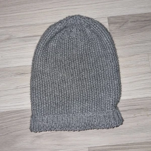 Grå stickad mössa - Snygg grå stickad mössa med ribbad kant. Perfekt för kyliga dagar och ger en stilren look. Hemmastickad.