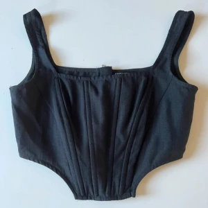 Svart korsett från SHEIN - Snygg svart korsett från SHEIN med dragkedja bak. Perfekt för att ge en stilren look. Tillverkad i ett bekvämt material som formar sig fint efter kroppen.