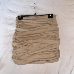 Beige kjol med rynkdetaljer - Snygg beige kjol med rynkdetaljer, det var från början en klänning som jag klippt av.