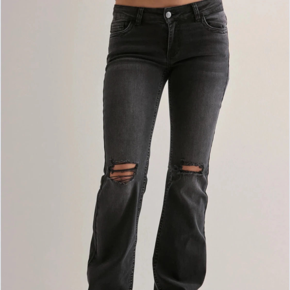 Svarta bootcut jeans med hål.