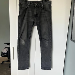 Grå/svarta jeans från Nudie Jeans - Säljer dessa grå/svarta jeans från nudie jeans. Storleken är 33 L 30 W och bra skick. Hör av dig vid frågor!