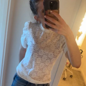 Vit spetsblus - Säljer en söt vit spetsblus med korta ärmar och puffiga axlar. Använd kanske max 3 gånger.