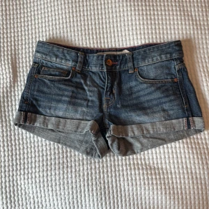 Lågmidjade jeansshorts  - Lågmidjade jeansshorts med uppvikta ben. I mycket bra skick. Storlek 27