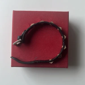 Svart armband med nitar från Valentino - Snyggt svart armband från Valentino Perfekt för att ge en nice touch till din stil. Kommer i originalförpackning med tillhörande påse, kort och extra nitar! 
