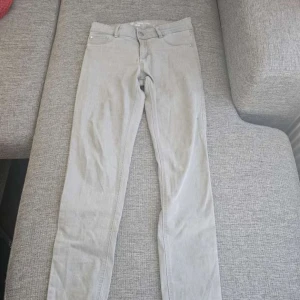 Grå jeans från Cubus - Snygga grå jeans från Cubus i modellen Jane. De är tillverkade i en bomullsblandning med elastan för extra komfort. Klassisk design med 4 fickor och knappgylf.
