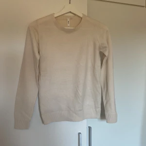 Beige tröja från Sinsay - Säljer en stilren beige tröja från Sinsay. Den har en klassisk rund hals och långa ärmar med ribbade muddar. Perfekt för en enkel och snygg look.