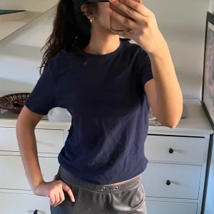 Mörkblå t-shirt - Säljer en stilren mörkblå t-shirt med rund hals. Perfekt för en avslappnad look. Passar till det mesta och är ett måste i garderoben! Köpt i Pakistan i storlek L men passar och sitter som en tight M eller lite lös S. 