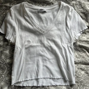 Vit v-ringad t-shirt  - Säljer en vit t-shirt med v-ringning.