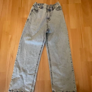 Grå jeansbyxor från Lindex - Säljer ett par grå jeansbyxor från Lindex. Byxorna har en loose passform och är högmidjade med elastisk midja. Perfekta för en avslappnad stil.