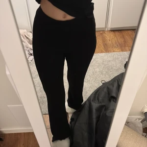 Svarta ribbade byxor - Snygga svarta byxor med ribbad textur och hög midja. De är i storlek XXS men som man ser på bilden är de väldigt stretchiga, så skulle tro att folk som har XS eller S kan ha dessa också. De är bra i längden för mig som är ca 164. Kommer ifrån Gina Tricot. 🖤