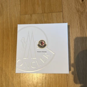 Moncler Pour Homme Parfymset - Exklusivt parfymset från Moncler för herrar. Innehåller en Eau de Parfum i en elegant silverfärgad flaska med räfflad design och en duschgel i svart tub. Perfekt för den stilmedvetna mannen som vill ha en lyxig doftupplevelse. Använd max 10 gånger :)