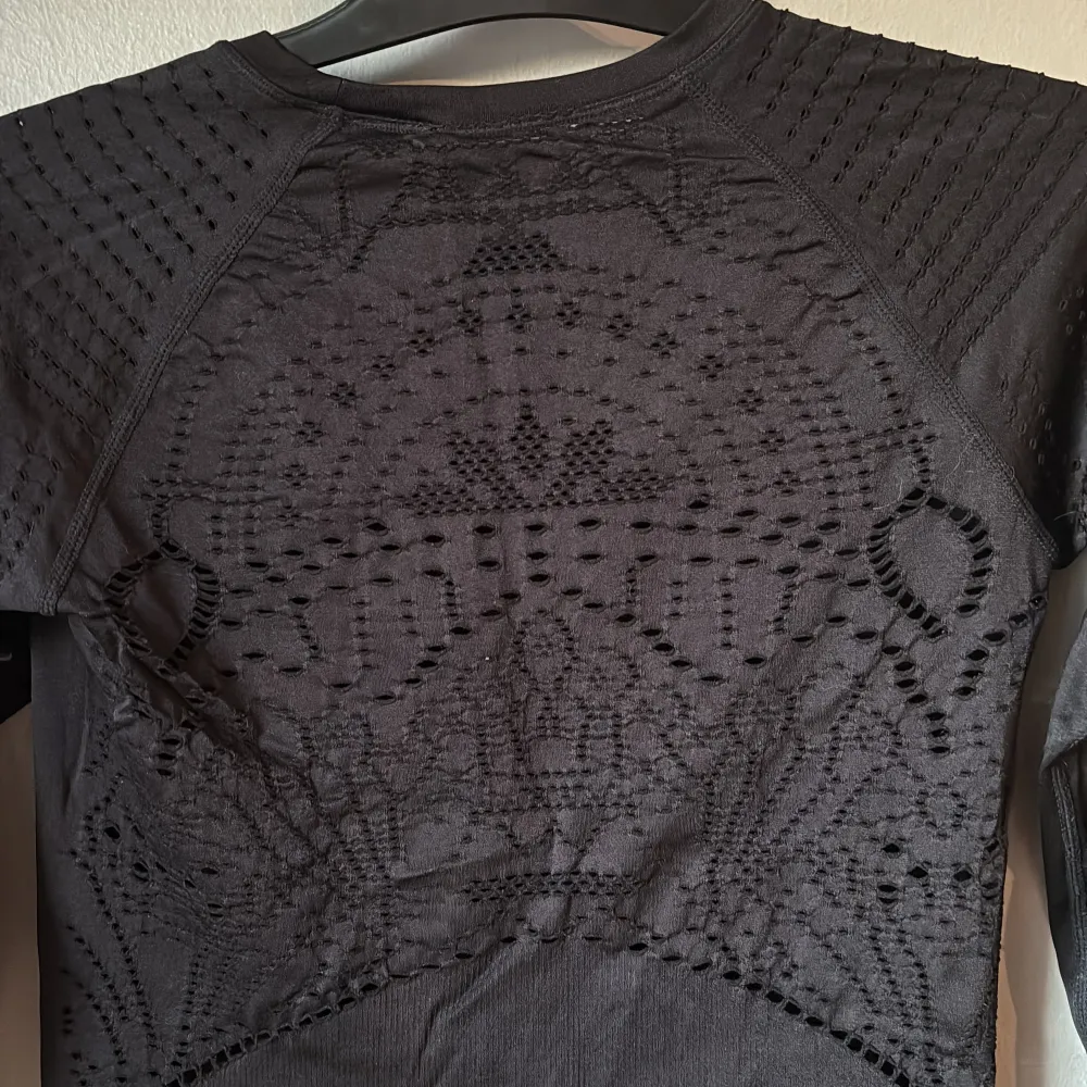 Snygg svart långärmad träningströja från H&M med coola perforerade detaljer på ärmar och rygg. Perfekt för en stilren look vid all träning;) Tröjan har en rund halsringning och är tillverkad i ett stretchigt material för extra komfort. Köparen står för eventuell fraktkostnad:)). Neuletakit & Villapaidat.