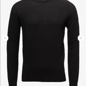 Tröja från Morris - Säljer en stilren svart tröja från Morris i 100% merinoull. Tröjan har en v-ringad design och ett diskret broderat emblem på bröstet. Perfekt för kyligare dagar och ger en elegant touch till din outfit. Den har tyvärr krympt väldigt, väldigt mycket i tvätten så det borde man tänka på innan man köper den. Priset kan såklart diskuteras☺️ kostar från början (1599kr)