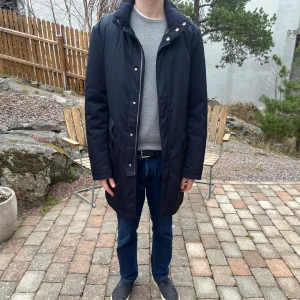 Mörkblå rock Allegri Milano - Säljer en stilren mörkblå rock med dragkedja och knappar. Rocken har långa ärmar och en klassisk krage. Perfekt för kyligare dagar.