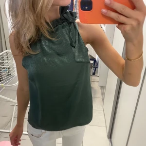 Halterneck topp - Snygg topp i grön/blå färg i glansigt material! Supersnygg nu till våren och sommaren! 