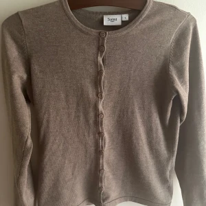 Brun kofta- saint tropez - Säljer en oanvänd kofta från saint tropez därav priset . Den är så fin och perfekt nu till våren💐säljer pga att den var för stor. Köpte för 349 kr och skulle säga att den passar s-m💕