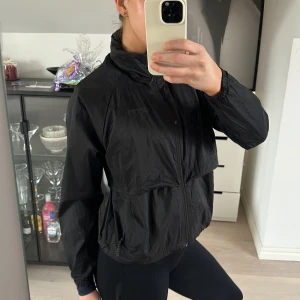 Svart vindjacka från Aim'n - Säljer en svart vindjacka från Aim'n med dragkedja framtill. Jackan har en hög krage och är långärmad, perfekt för blåsiga dagar. Den är lätt och smidig att bära med sig.💗💗originalpris 999kr.