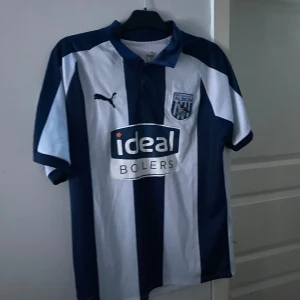 Randig West Bromwich från Puma - Passar bra på mig med M, ett litet hål som jag själv inte märkte förens jag gick igenom tröjan jätte noggrant, kolla bild 3 för att se