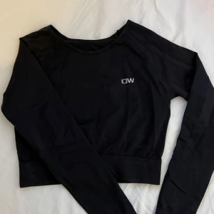 Svart croppad tränings tröja från ICANIWILL - Säljer en svart croppad tränings tröja från ICANIWILL. Tröjan har långa ärmar och en stilren design med logotypen på bröstet. Passar bra till både träning och vardag. Anvånd fåtal gånger och är i fint skick