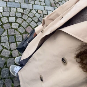 Beige trenchcoat - Snygg beige trenchcoat med klassiska knappar och stilren design. Perfekt för en elegant look i stan. Passar bra till både sneakers och klackar.