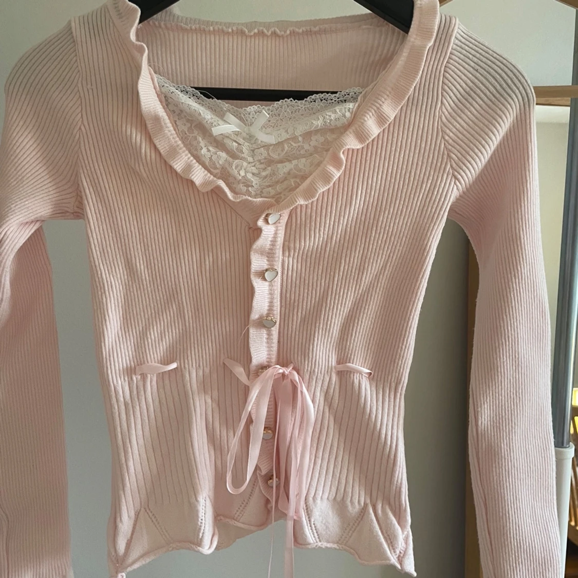 Rosa ribbad kofta med spetsdetaljer