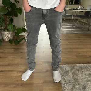Replay Anbass Hyperflex  - Snygga grå jeans från Replay med en klassisk femficksdesign och dragkedja. De har en slim passform och är tillverkade i ett bekvämt jeansmaterial. Perfekta för en stilren look. W.28 L.32