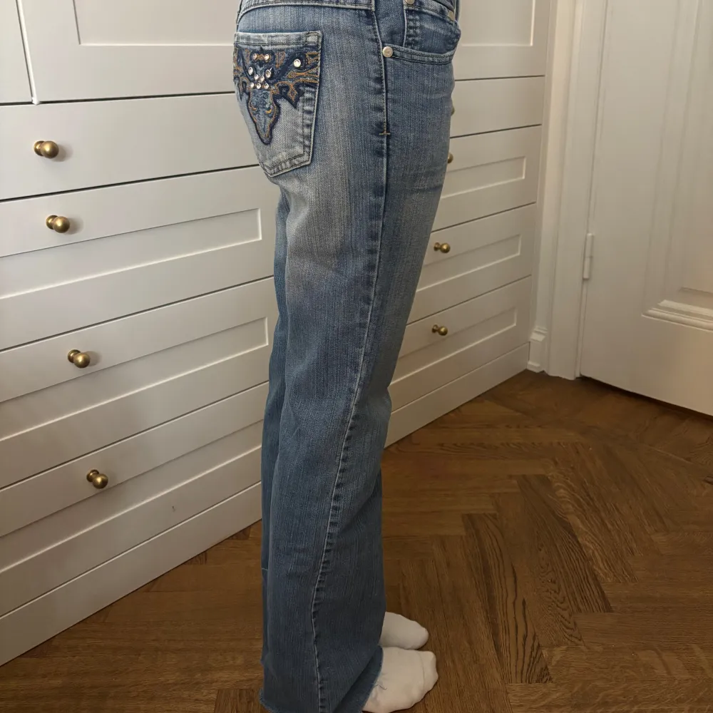 Snygga blå jeans med låg midja. De har unika bakfickor med glitter. Farkut & Housut.