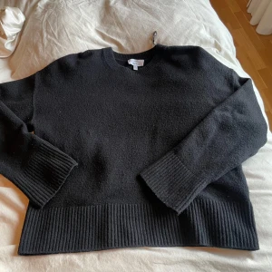 Svart stickad tröja från  - Säljer en stilren svart stickad tröja från & Other Stories Tröjan har långa ärmar och ribbade detaljer vid ärmslut och nederkant. Perfekt för kyligare dagar. Hör av dig vid intresse!
